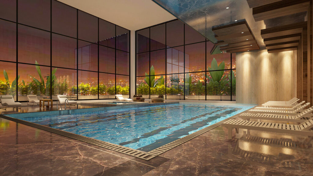 An indoor pool in a luxurious atmosphere with large glass windows surrounding it.